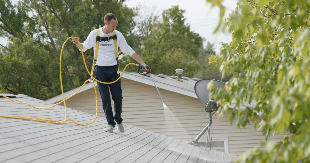Roof Renew technician applying Peak 301 to an asphalt shingle roof in Utah